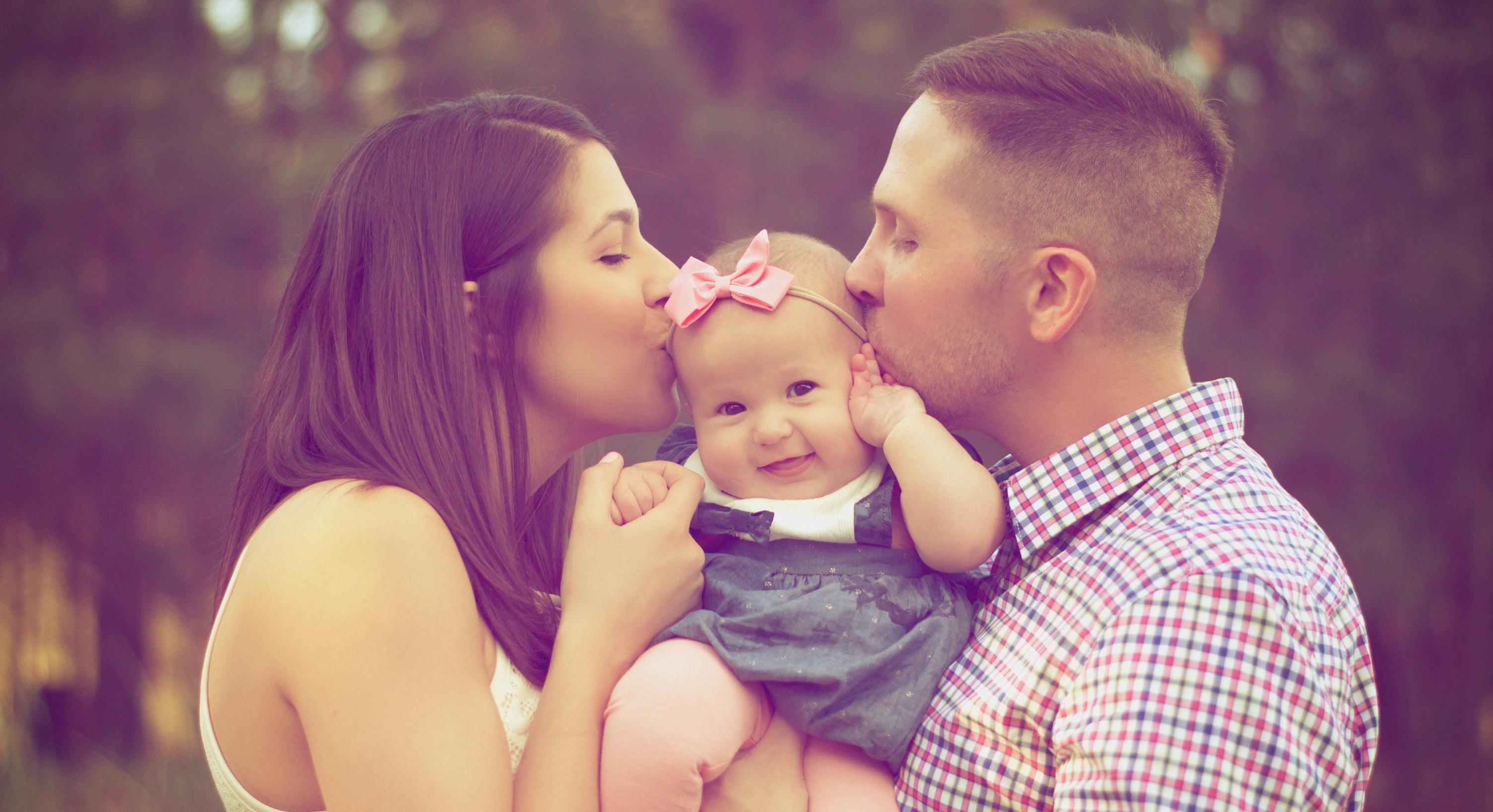 couple kissing baby